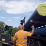 loading blue water pipe onto lorry